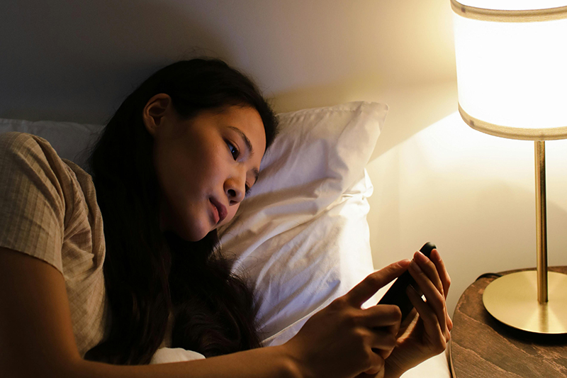 Women looking at her phone before bed.
